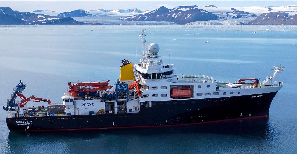 Research vessel sailing with arctic mountains in background