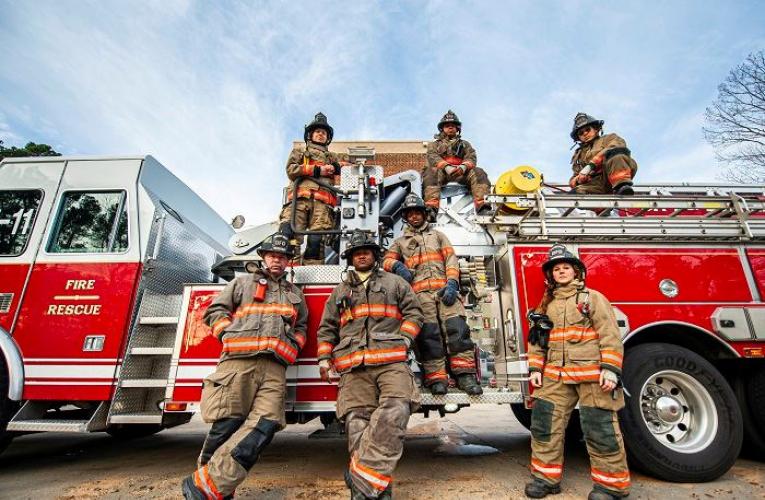 Firefighters posing around a fire truck