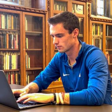 Danny Collins typing on laptop in library