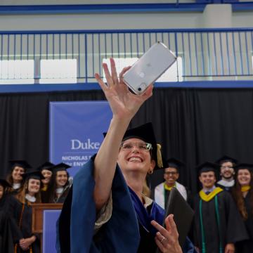 Dean Toddi Steelman takes selfie with graduates 